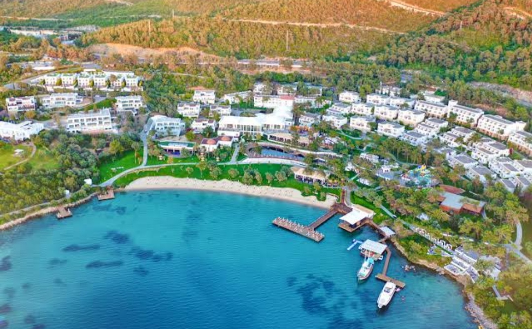 Luxury resort with white villas by a turquoise bay in Bodrum.