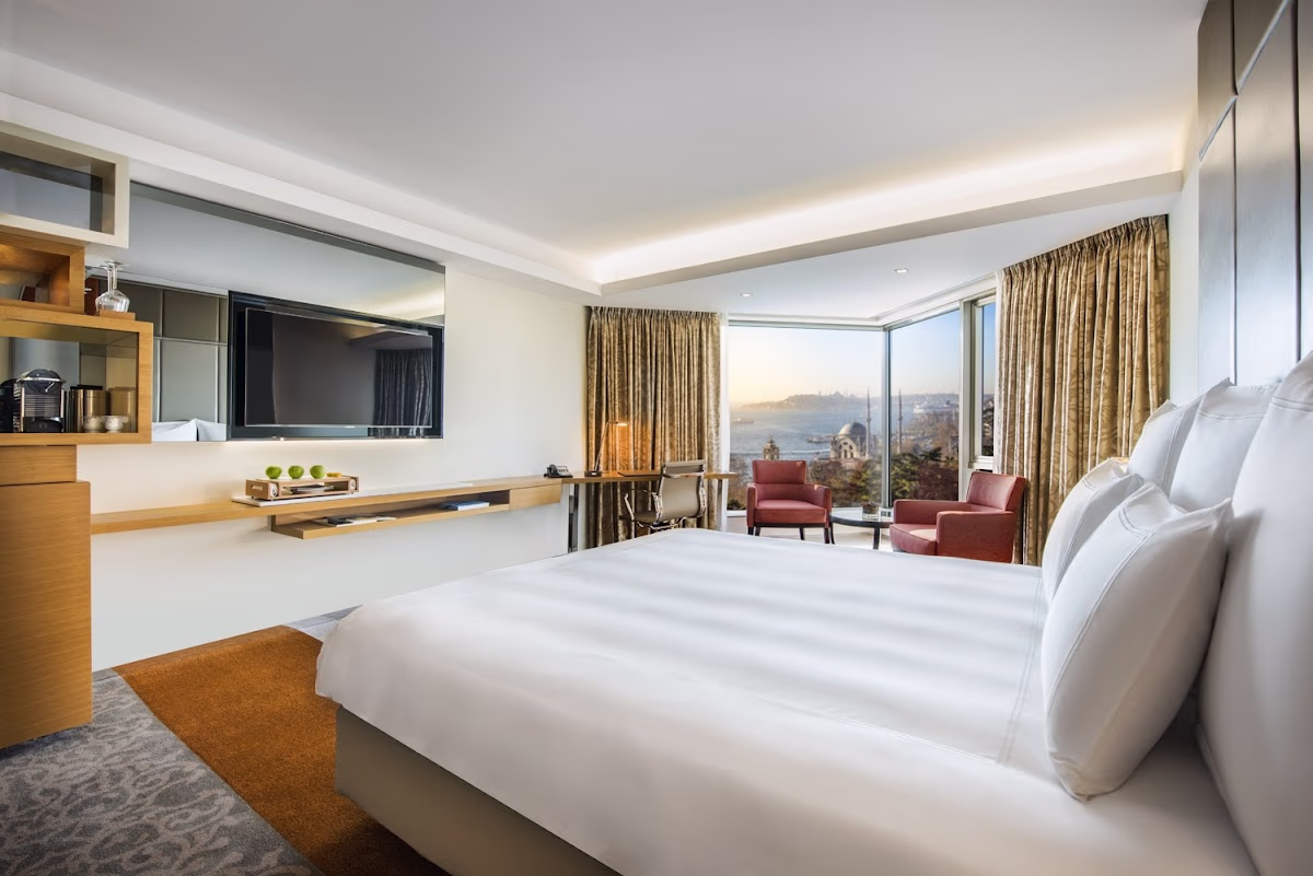 Boğaz manzaralı modern Swissotel yatak odası ve çalışma alanı.