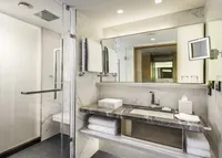 Luxurious marble Swissotel bathroom with shower and vanity area.