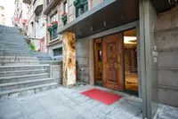 Entrance of DK Select Regency Suites with marble pillar and wooden door.