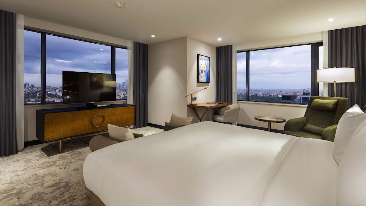 Spacious and modern room at Hilton Istanbul Maslak with a king bed and panoramic windows offering a stunning city view.