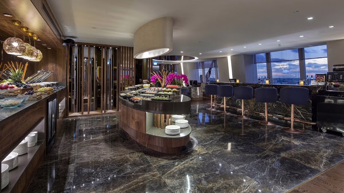 The elegant Executive Lounge at Hilton Istanbul Maslak with a gourmet buffet, bar seating, and expansive city views.