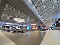 Područje za preuzimanje prtljage s modernom kružnom rasvjetom i praznim trakama.