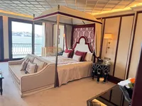 Luksuzni apartman Palace u Çırağan Kempinski s krevetom s baldahinom, elegantnim namještajem i velikim prozorom s pogledom na Bospor.