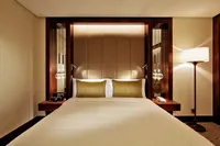 A luxurious guest room at Conrad Istanbul Bosphorus, featuring a comfortable king-size bed and warm, ambient lighting.