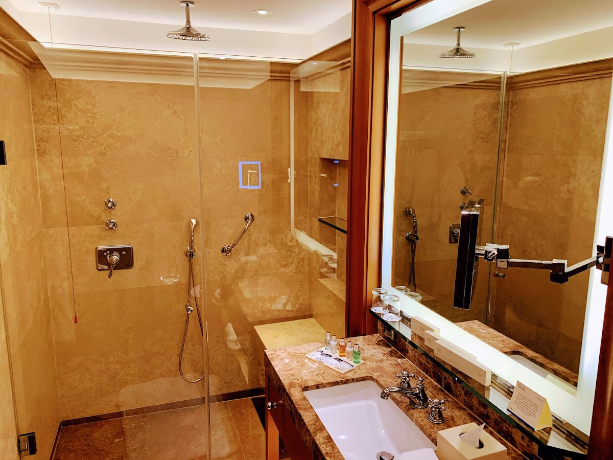 Luxury marble bathroom in Divan Istanbul hotel room with spacious shower and elegant sink.