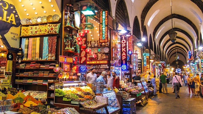 Shops selling spices, lamps, and textiles in the historic Spice Bazaar corridor.