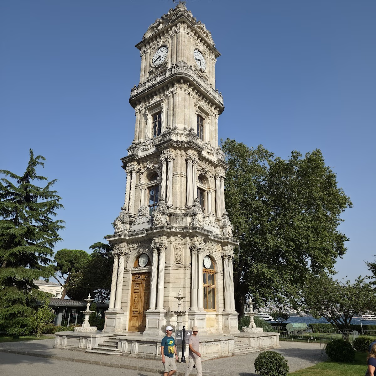 Dolmabahçe-Uhrturm, Steinarchitektur im Barock- und Empirestil unter blauem Himmel.