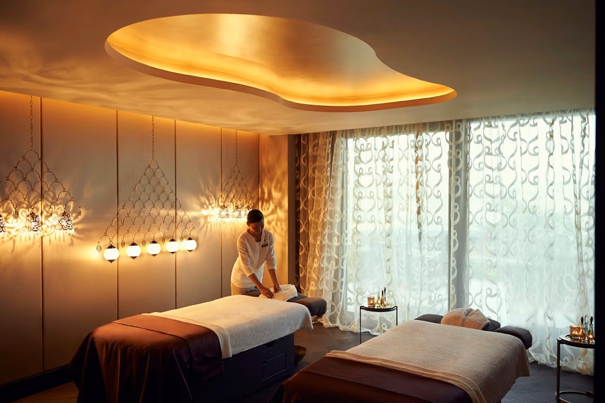 Raffles İstanbul spa odasında masaj yatakları ve sıcak aydınlatma.