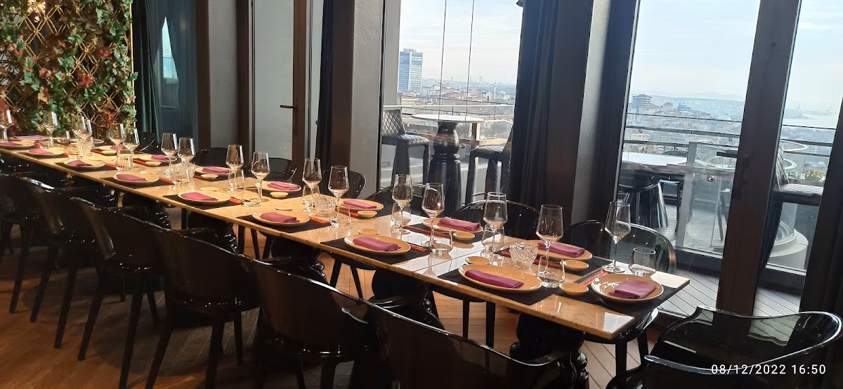 Elegant dining table set at Fairmont Quasar Istanbul with panoramic city views and Elemen Transfer service.