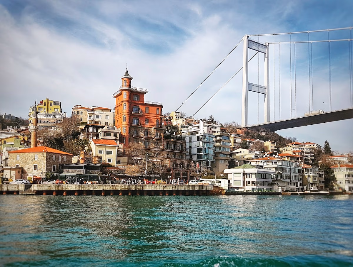 Boğaz kıyısında renkli binalar ve Fatih Sultan Mehmet Köprüsü'nün alt kısmı.