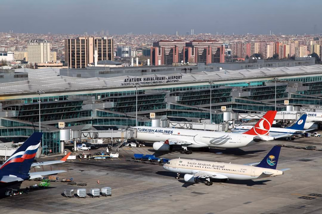 Turkish Airlines and other planes on the tarmac at the historic Atatürk Airport (ISL) with the city in the background.