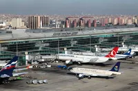 Turkish Airlines and other planes on the tarmac at the historic Atatürk Airport (ISL) with the city in the background.