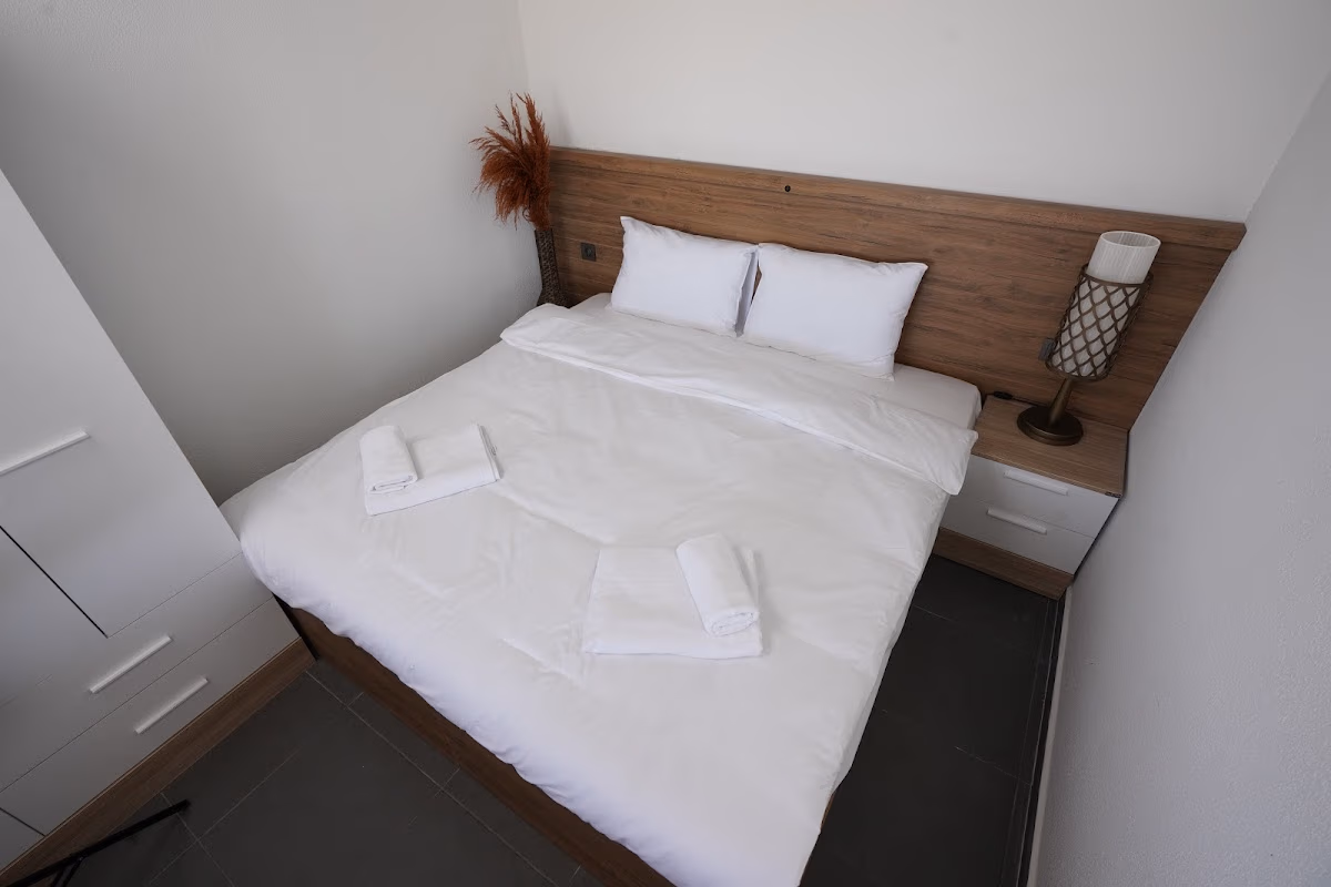 Marin Beach Hotel'in modern bir odasında, dinlendirici bir konaklama için hazırlanmış beyaz çarşaflı konforlu çift kişilik yatak.