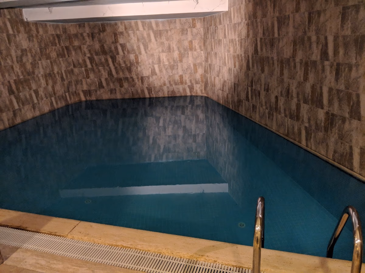 Piscina interioară liniștită de la Hotelul Sirkeci Mansion, oferind un spațiu calm pentru relaxare cu apa sa liniștită și iluminarea caldă.