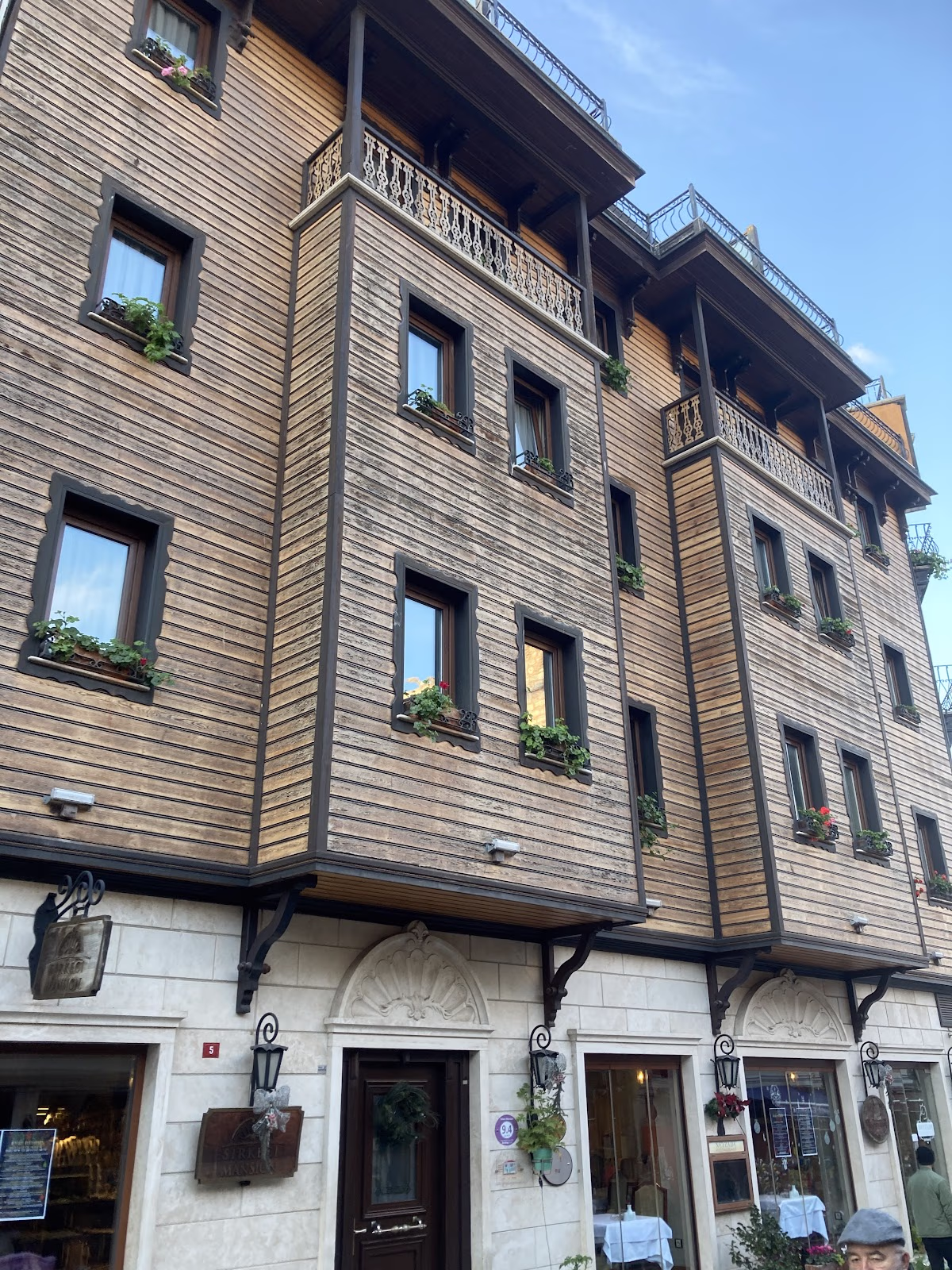 Un prim-plan al arhitecturii tradiționale din lemn în stil otoman a Hotelului Sirkeci Mansion, cu balcoanele sale intricate și jardinierele de la ferestre.
