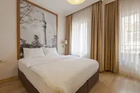 Modern hotel room with Beyazıt Tower wallpaper and a large double bed.