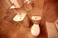 Clean and modern hotel bathroom with marble-patterned tiles and white fixtures.
