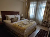Comfortable double bed with elegant linens and decorative pillows at Sultanahmet Suites.