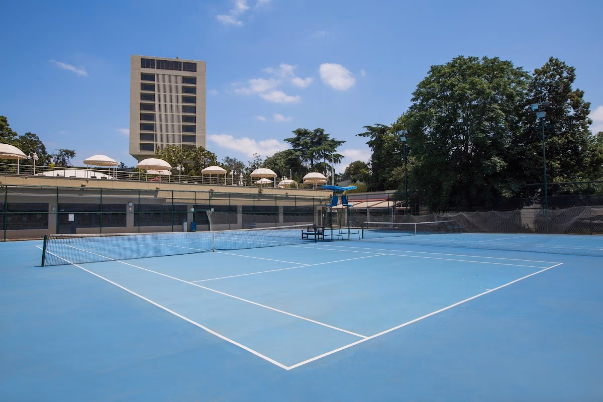 Blue tennis courts at Hilton Istanbul Bosphorus with hotel tower in background.