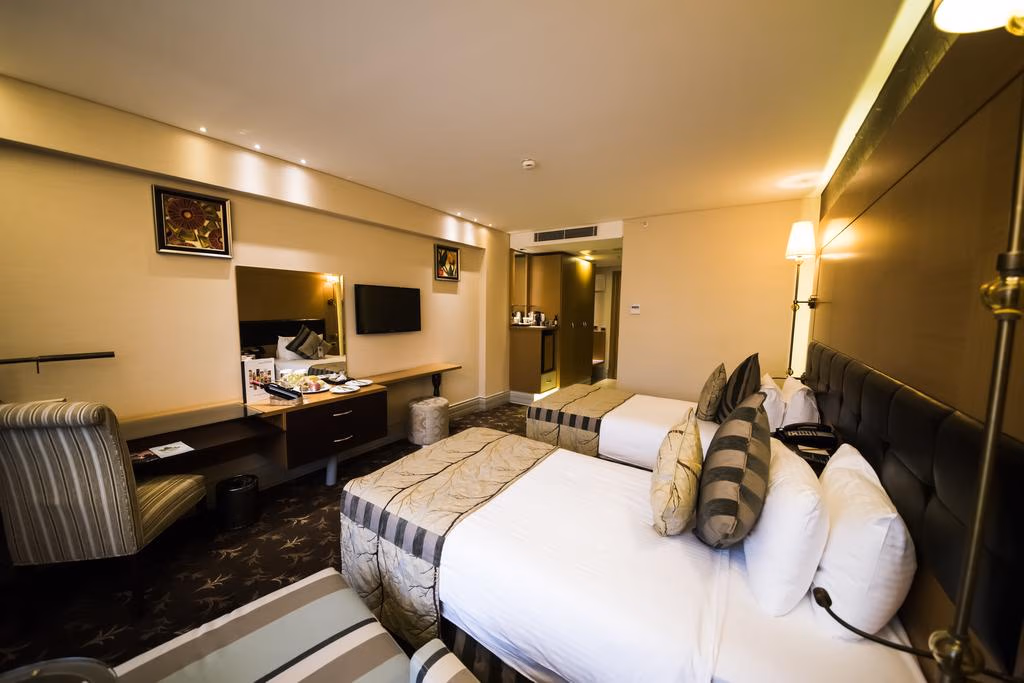 Taksim Gönen Otel'de iki yataklı, modern dekore edilmiş, sıcak aydınlatmalı konforlu bir oda.