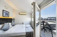 Modern bedroom at Taksim Trust Hotel with balcony entrance and city view.