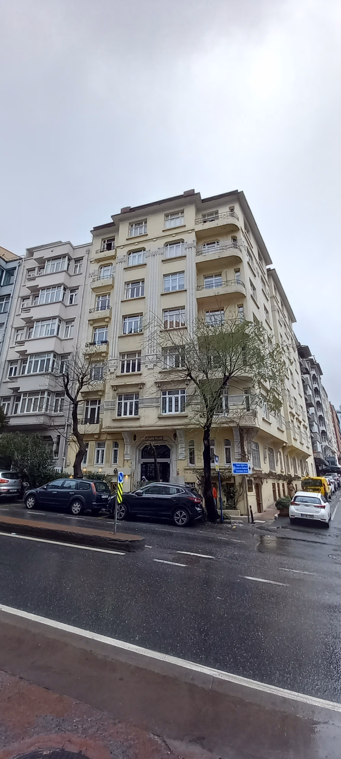 A corner view of a classic early 20th-century apartment building in Ankara, with ornate details and balconies.