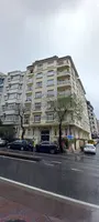 Ankara Palas apartment building facade and cars parked on a wet street.
