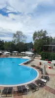Vanjski bazen Swissotela s ležaljkama i pogledom na bujni vrt.