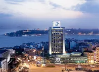 The Marmara Taksim otel binası ve gece İstanbul Boğazı manzarası.