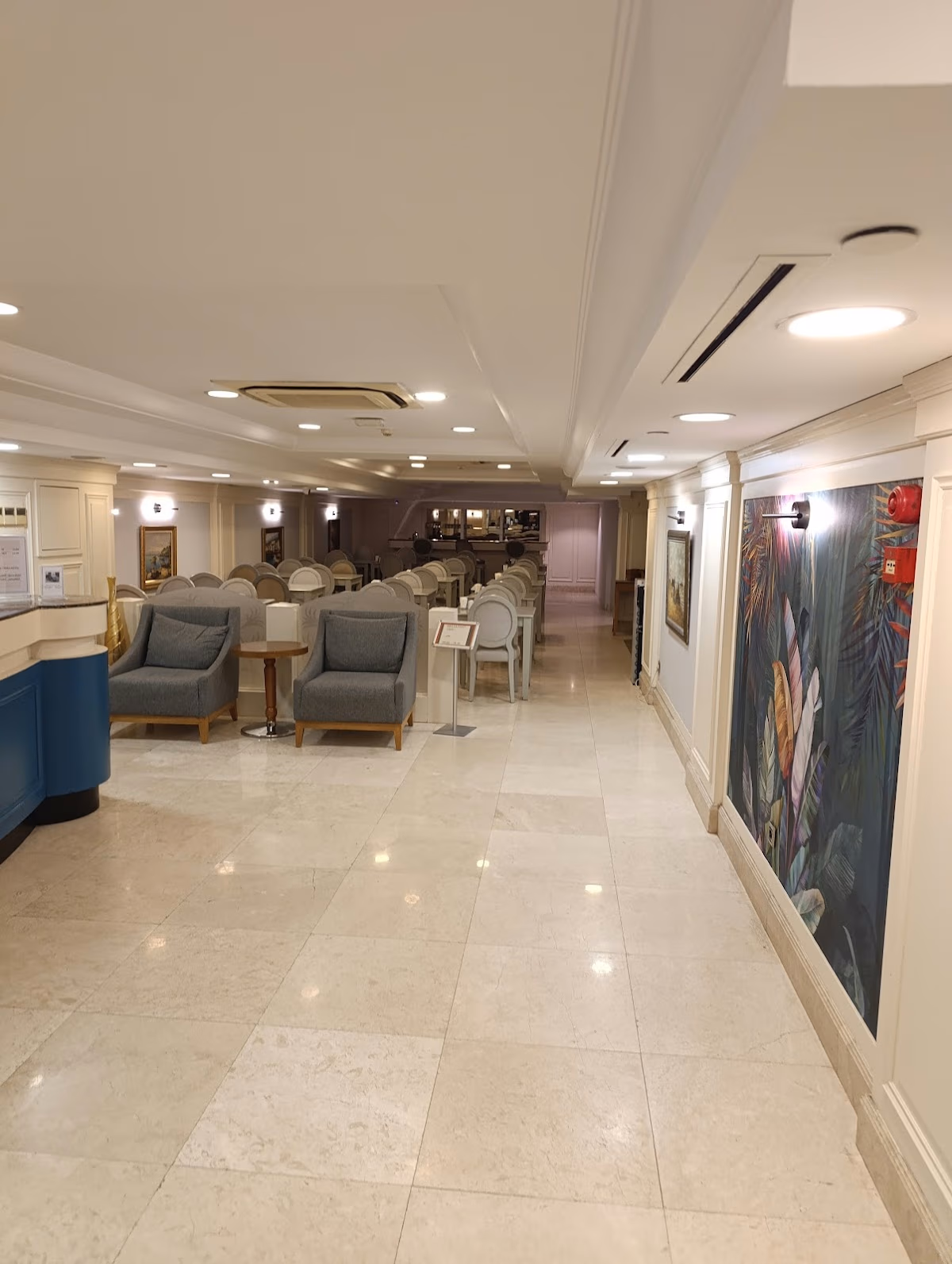 Taksim Stare Hotel'in konforlu gri koltuklar ve zarif mermer zeminlere sahip geniş ve aydınlık lobi salonu.