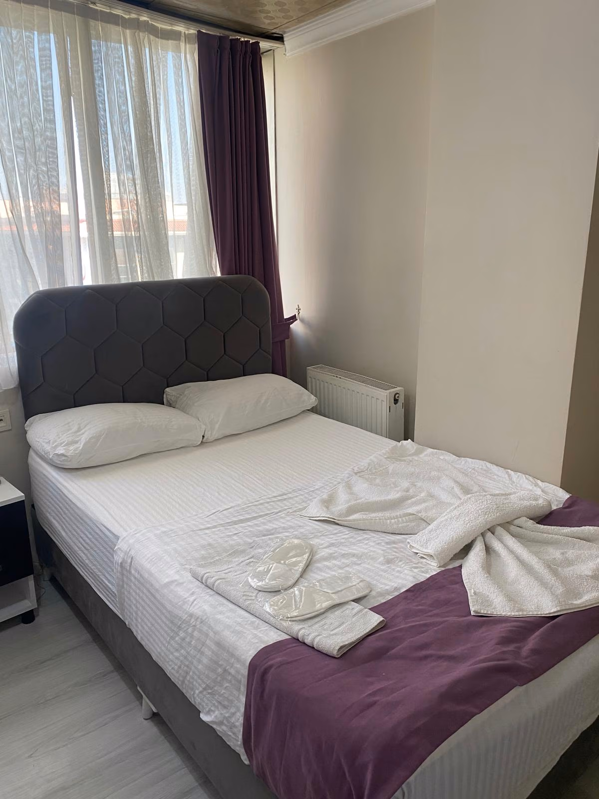 A guest room at Bağcılar Kümbet Otel prepared with a comfortable double bed, fresh towels, and slippers.