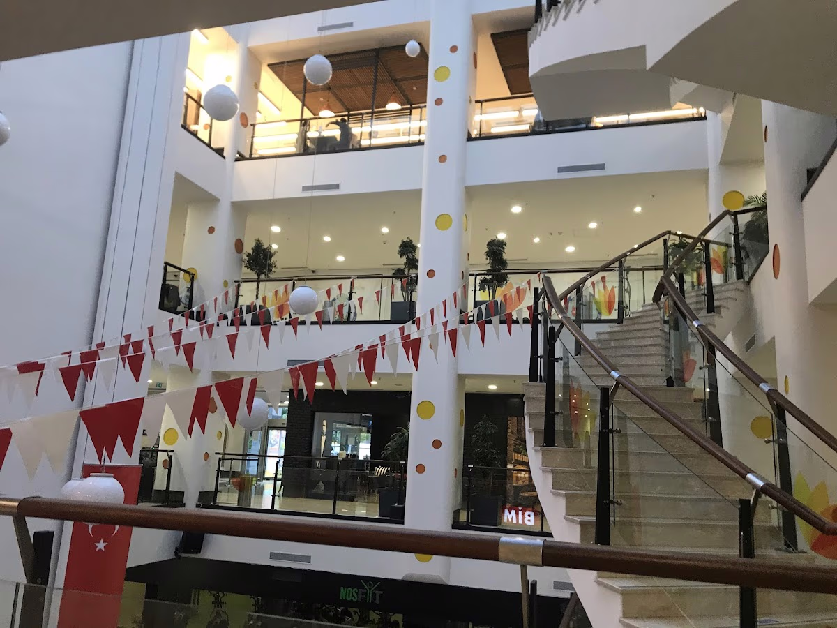 Güngören Park AVM'nin çok katlı, aydınlık iç mekanı, merdivenler ve kırmızı beyaz bayrak süslemeleri.
